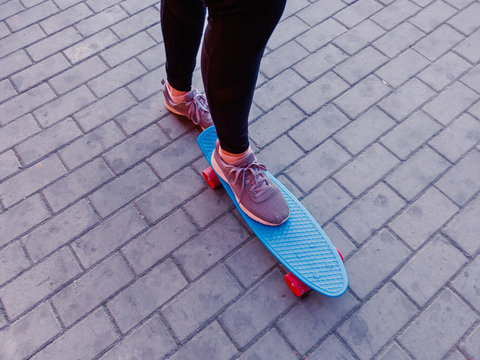 A picture of a girl who put her foot in sneakers on a skateboard top view