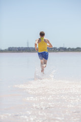 Man running in water on the beach