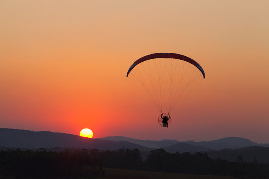 paramotor flying silhouette at sunset