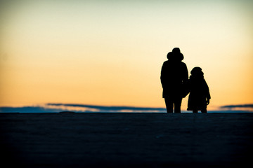 Concept of friendly family.  Silhouette of family members on walking in the sunset 