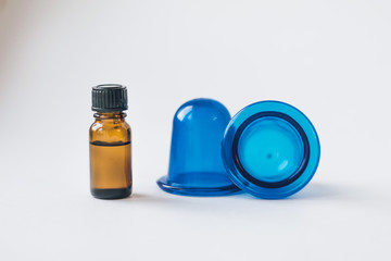 Body care, against cellulite. Home methods and means for beauty. Cupping massage. Rose essential oil in a dark glass jar. On a white isolated background