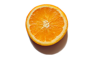 orange slice on a white background with a shadow from the sun