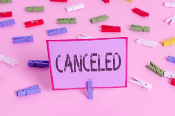 Writing note showing Canceled. Business concept for to decide not to conduct or perform something planned or expected Colored clothespin papers empty reminder pink floor office pin