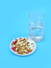Medicine pills and glass of water on blue background. treatment medication concept. Pharmaceutical medicament, health care, treatment of diseases.