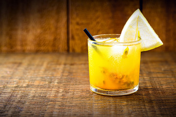 Brazilian caipirinha, cachaça drink with fruits, on wooden background. passion fruit flavor