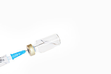 syringe needle injecting into vaccine bottle