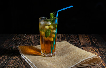 Apple cocktail on a bar counter against a dark background. Apple and mint cocktail on a bar counter in a club.