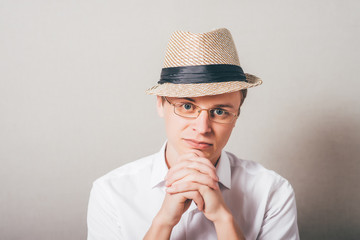 portrait of a man in a hat who folded his hands to pray