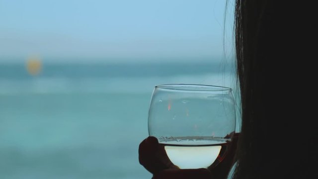 Woman drink wine and look how people Kite surfing in beautiful clear water in Dahab Egypt. Exploring the blue sea with mountains in the background and people kite surfing, slow motion, full hd