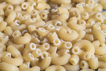 Pasta in the shape of horns texture. Pasta from wheat flour twisted horns.