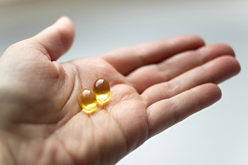 Close up omega 3 vitamin capsule in hand. capsule fish oil in hand. Useful supplement, healthy food