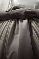 The body of a living sculpture of a young woman, her hands are on a pregnant belly