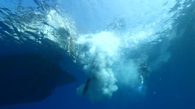 scuba divers jumping in water from boat underwater ocean scenery