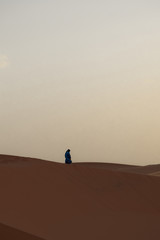 Fototapeta na wymiar Bereber camina solo por el desierto
