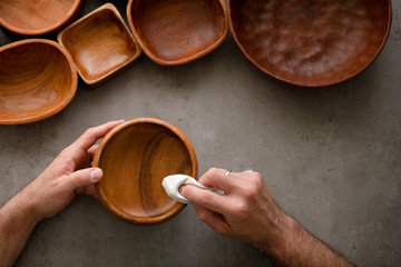 Men's hands polish wooden bowls	
