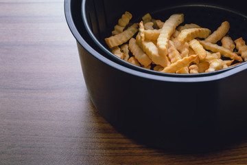 French fries on an oil-free frying pan, On the wood table background,  Delicious and healthy because it's not oil in cooking, Selective focus.