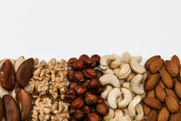 Raw nuts isolated on white background with empty copy space, almonds, cashews, hazelnuts, Brazil nuts and walnuts