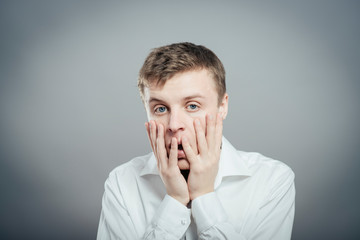 a young man upset with hands on face