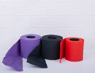 Red, Purple and Black Paper Toilets Rolls on White Background. .