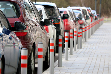 Cars in a row and parking barriers on a parking lot in a yard of residential district. Quarantine in city during the epidemic of the coronavirus