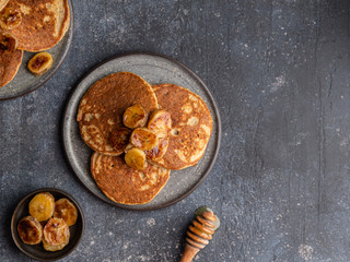 Oatmeal banana pancakes with honey and babana slices on ceramic plate. Healthy easy making morning breakfast. Homemade sugar free and gluten free food. Concrete background, top view. Copy space.