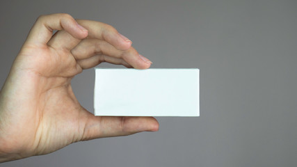 Woman hand holding white box for text or advertising concept. A box of medicines in a woman's hand.