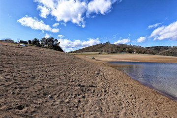 Wide sandy beach by loosed dam water level