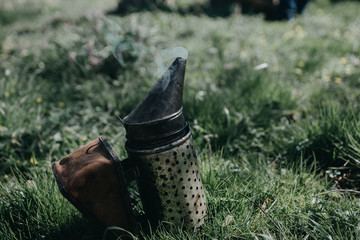 Chimney for flashing bees. Chimney stands near beehives.The beekeeper's tool. Bee smoker smoking.