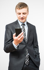 The man is using a smartphone. Modern mobile phone in hand.