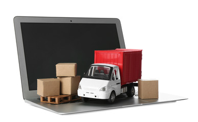Laptop, truck model and carton boxes on white background. Courier service