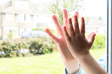 Father and son`s hands  separated by glass themes of isolation imitation bonding