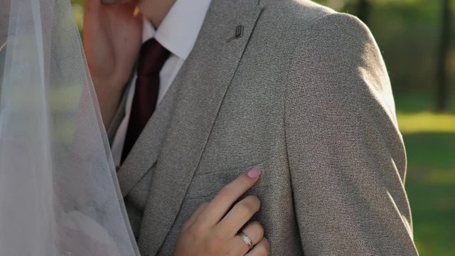 Wedding couple. The bride hugges the groom. Bride and groom embracing outdoors. Man and woman in love. Lovely groom and bride. Wedding day.