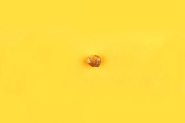 Caramel popcorn isolated on a yellow background, scattered. Mockup, frame of popcorn, top view.