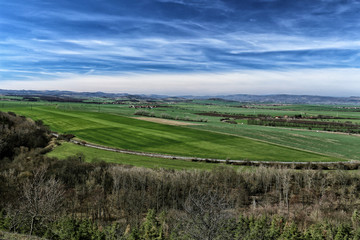 Fototapeta na wymiar Flat countryside with green fields and railway track