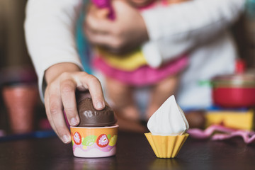 little girl plays wit ice cream toys