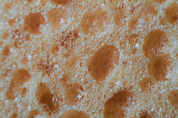 Abstract background yellow sponge for washing dishes close-up, selective focus