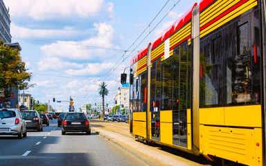Trolley and cars in road in Warsaw city center reflex