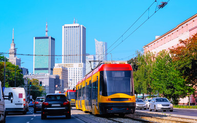 Fototapeta na wymiar Trolley and cars on road in Warsaw city center reflex