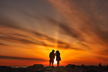 Fototapeta premium Alone together social distancing couple silhouette by the lake shore 