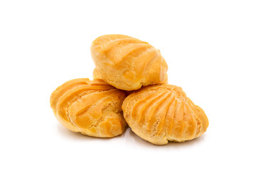 Group of three whole baked golden profiterole in line isolated on white background. Profiteroles with cream on a white background