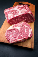 Raw dry aged wagyu entrecote beef steak roast as top view on a modern design wooden board