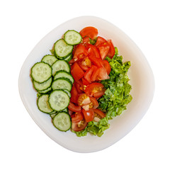 vitamin salad of tomatoes, cucumbers, spinach and spicy greens in white porcelain bowl isolated on white