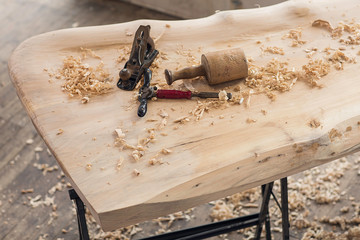 Wood shavings, wood curls and an old spokeshave  on a wooden poplar table. Old carpentry tools