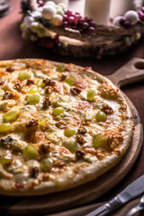 Pizza with various cheese, walnuts and grapes