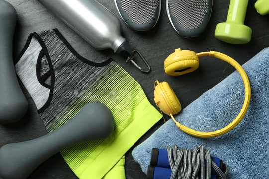 Set of fitness equipment and accessories on black background, flat lay