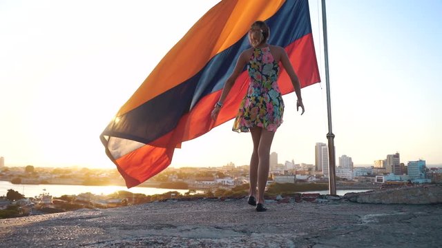 colombian flag and girl in golden and optimist sunshine full of patriot 
