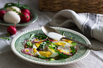Vegetarian salad with dandelion leaves, vegetables, egg and sour cream. Rustic style.