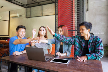 College students using laptop together in cafe