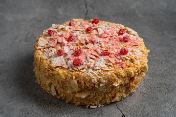 Round multi-layered cake Napoleon on gray concrete background. place for text. concept sweet-shop bakery