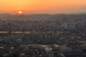 山頂より岡山市の市街地に日が沈む夕刻の風景